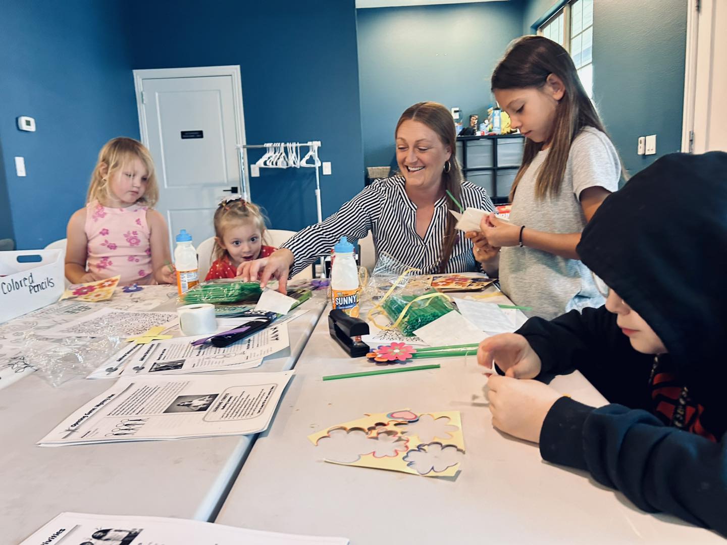 Children making crafts with a church volunteer